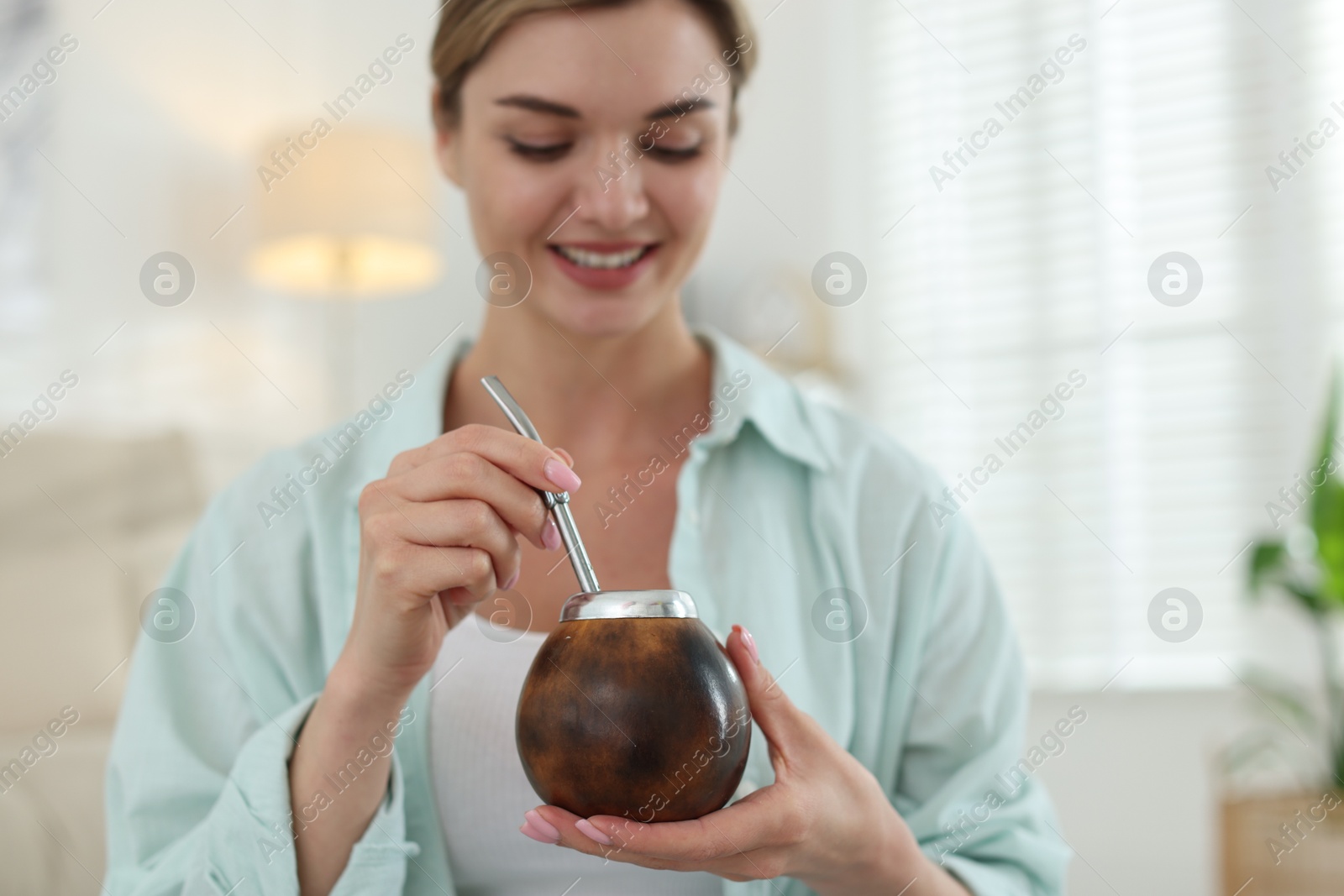 Woman with traditional yerba mate tea at home, selective focus Photo of Woman with traditional yerba mate tea at home, selective focus