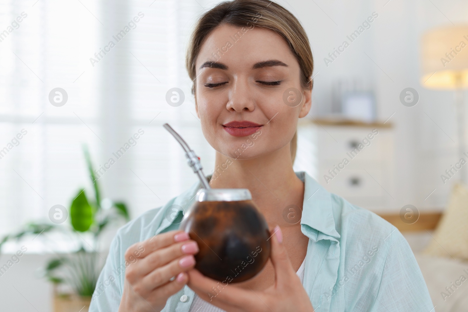 Woman with traditional yerba mate tea at home Photo of Woman with traditional yerba mate tea at home