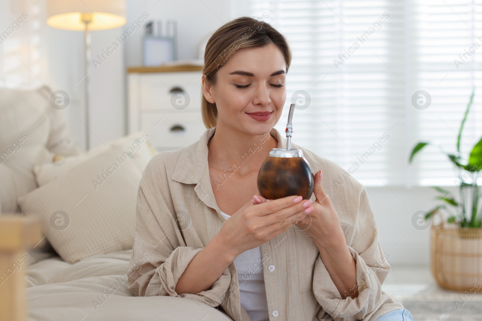Woman with traditional yerba mate tea at home Photo of Woman with traditional yerba mate tea at home