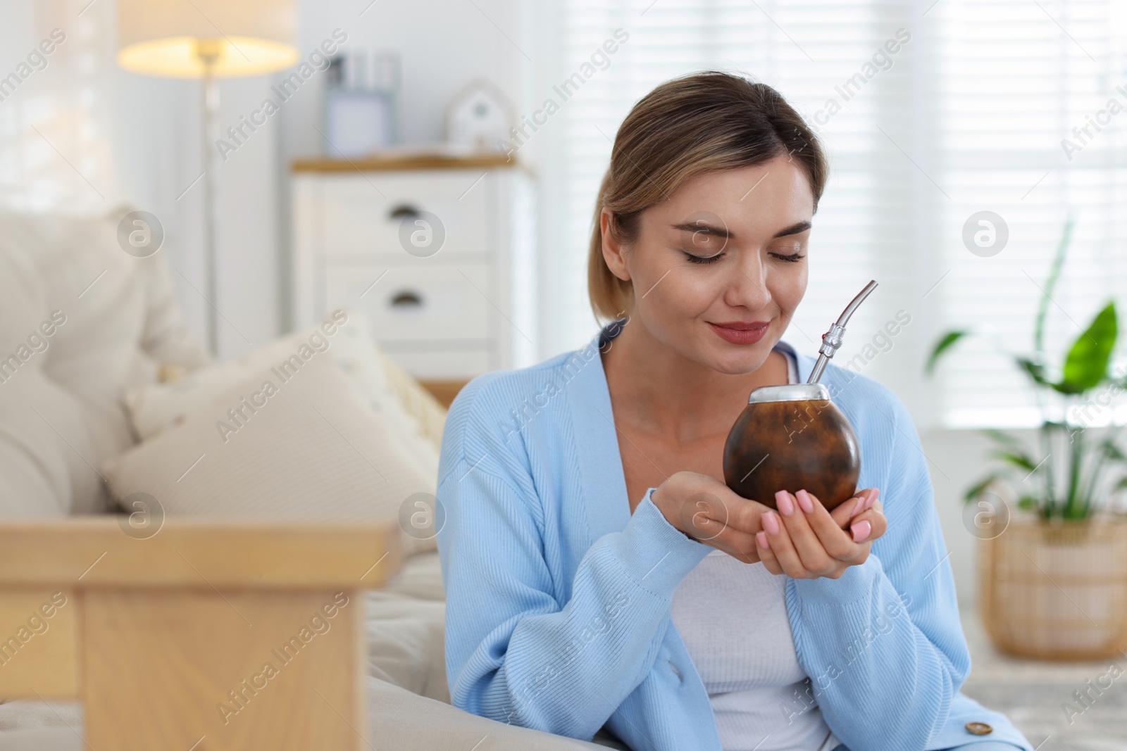 Woman with traditional yerba mate tea at home, space for text Photo of Woman with traditional yerba mate tea at home, space for text