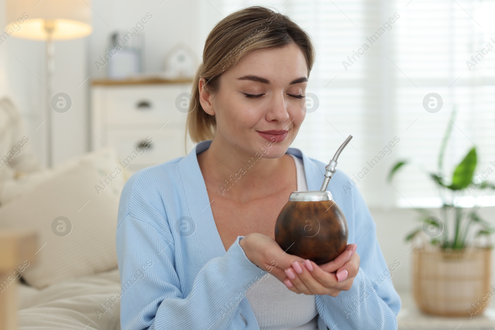 Woman with traditional yerba mate tea at home Photo of Woman with traditional yerba mate tea at home