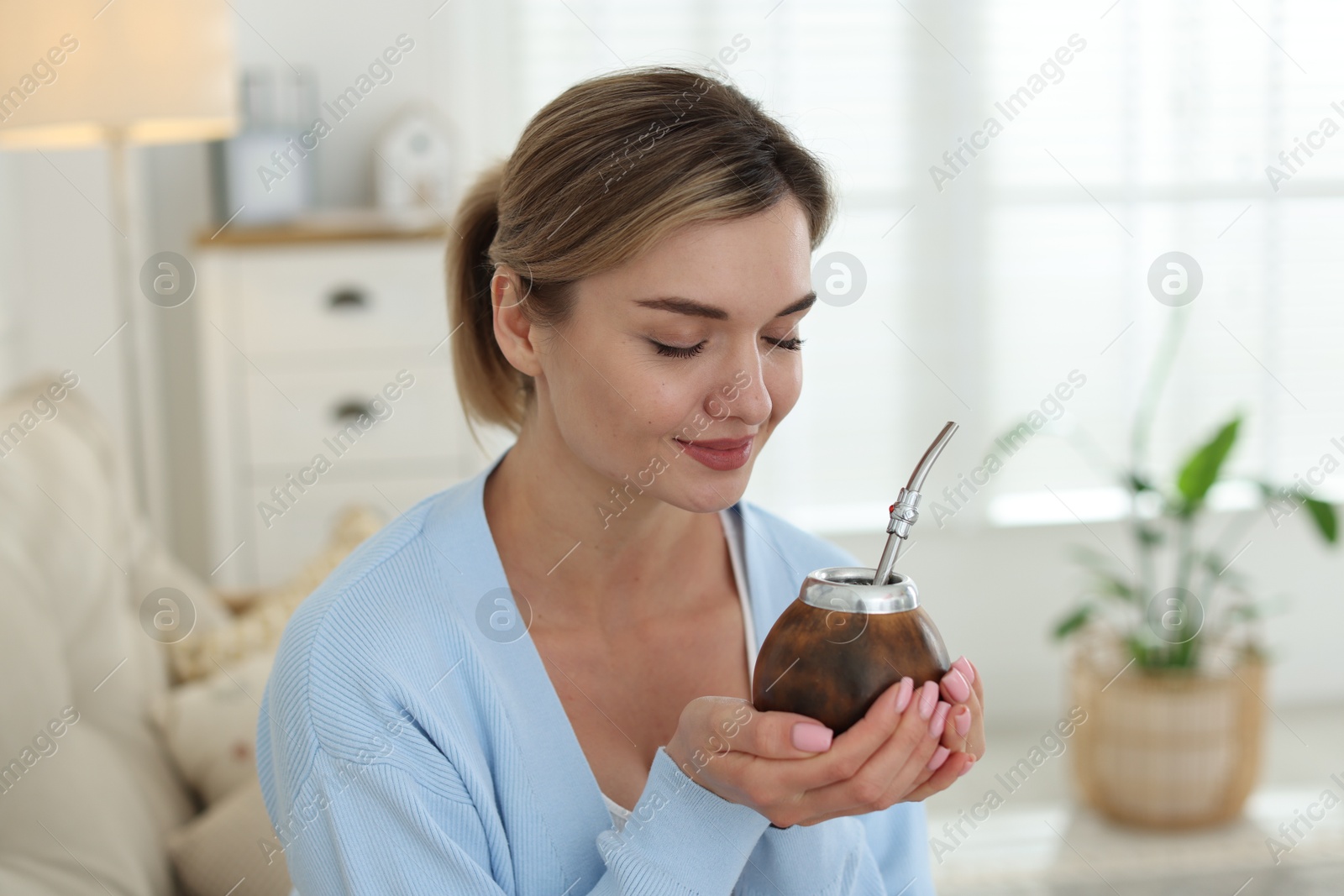 Woman with traditional yerba mate tea at home Photo of Woman with traditional yerba mate tea at home