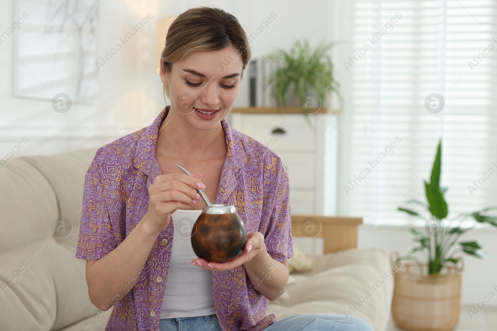 Woman with traditional yerba mate tea at home, space for text Photo of Woman with traditional yerba mate tea at home, space for text