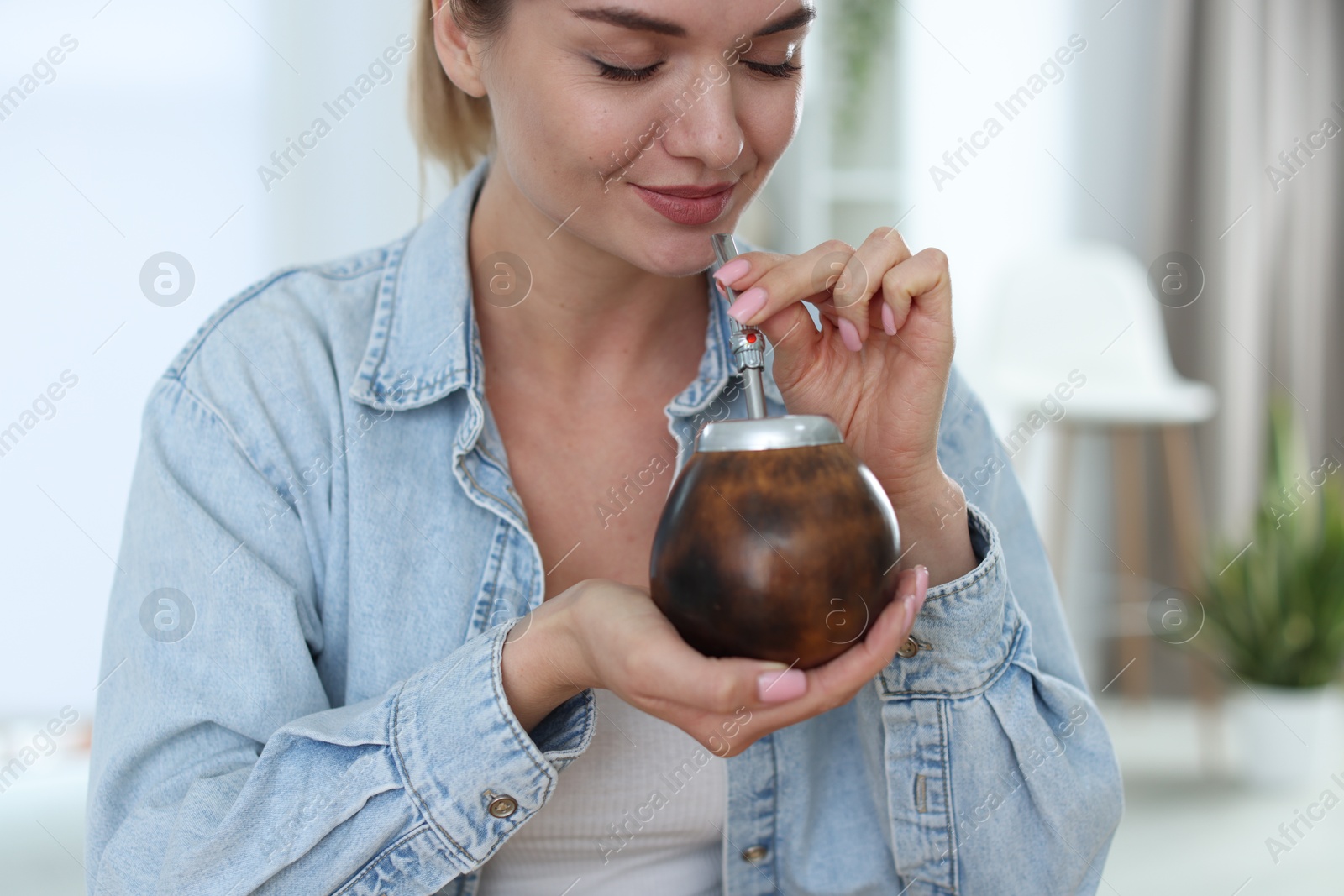 Woman drinking traditional yerba mate tea at home Photo of Woman drinking traditional yerba mate tea at home