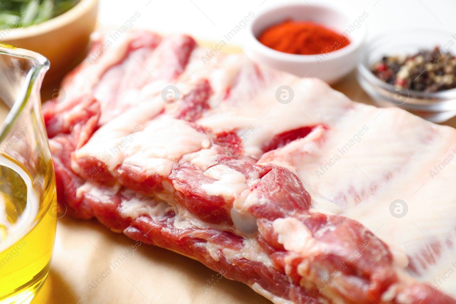 Raw pork ribs with spices and oil on white table, closeup Photo of Raw pork ribs with spices and oil on white table, closeup