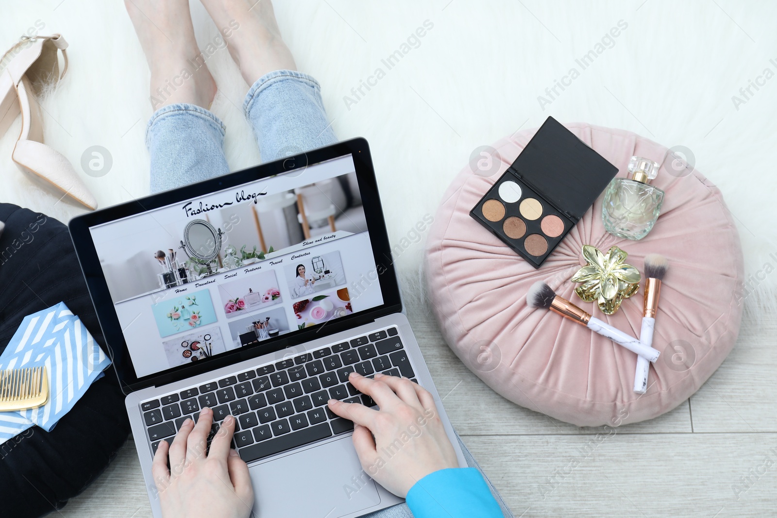 Blogger using laptop with fashion blog web site on floor indoors, above view Photo of Blogger using laptop with fashion blog web site on floor indoors, above view