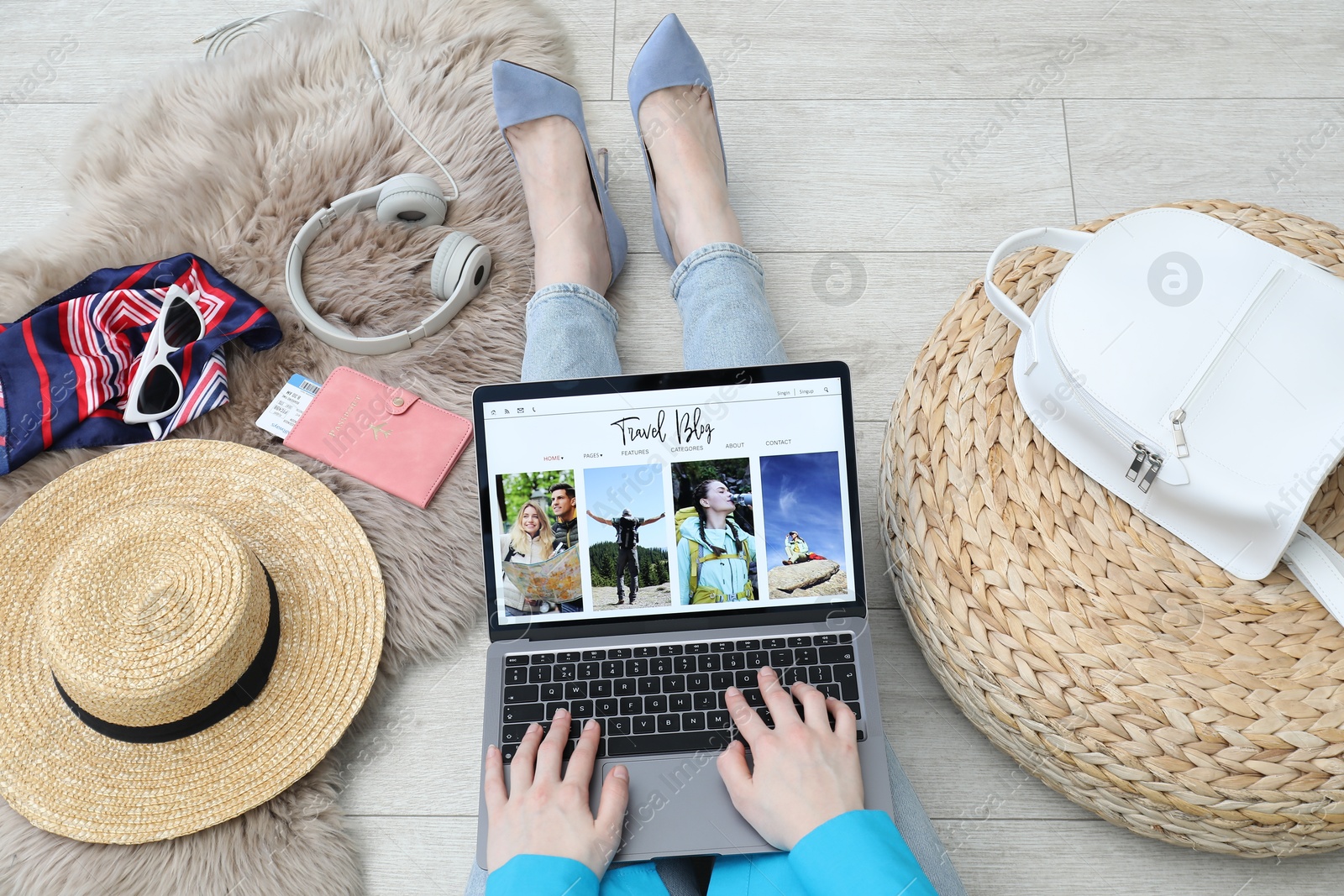 Blogger using laptop with travel blog web site on floor indoors, above view Photo of Blogger using laptop with travel blog web site on floor indoors, above view