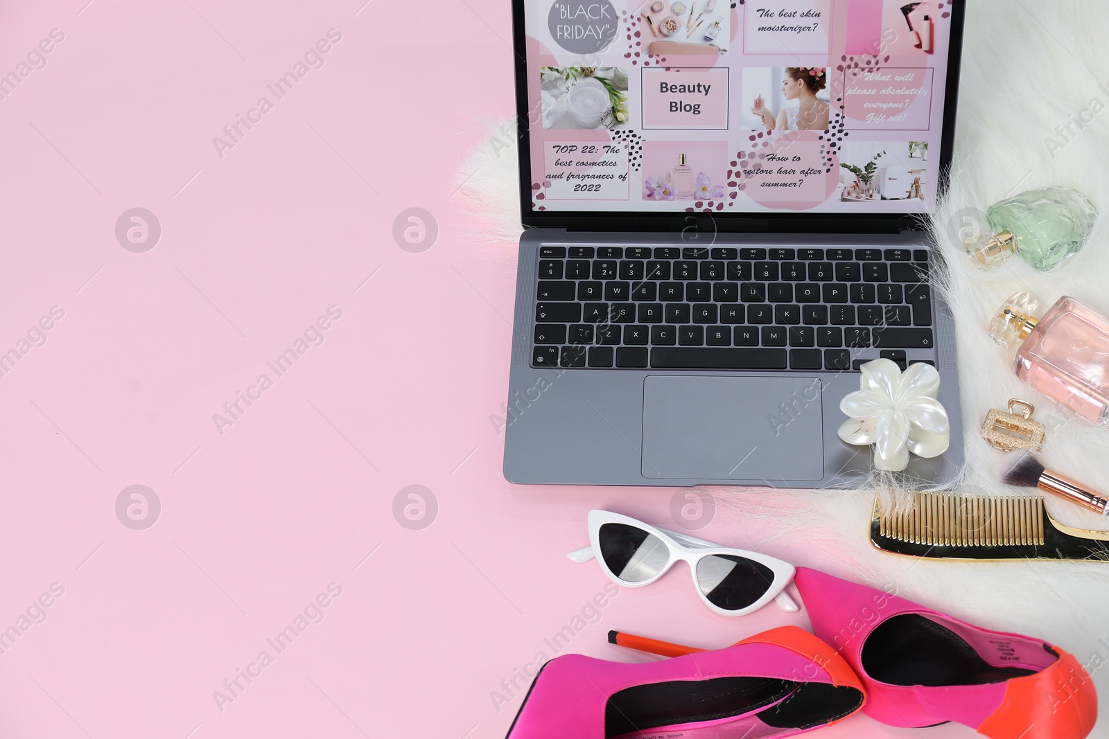 Laptop with beauty blog web site, shoes, perfumes and different accessories on pink background, above view. Space for text Photo of Laptop with beauty blog web site, shoes, perfumes and different accessories on pink background, above view. Space for text