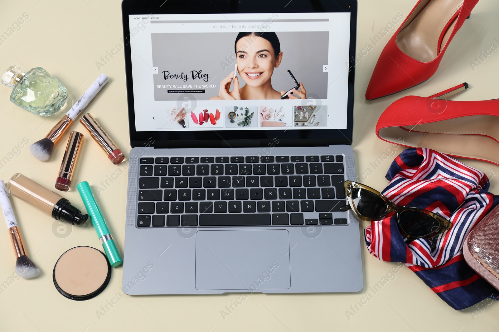 Laptop with beauty blog web site, shoes, accessories and makeup products on beige background, above view Photo of Laptop with beauty blog web site, shoes, accessories and makeup products on beige background, above view