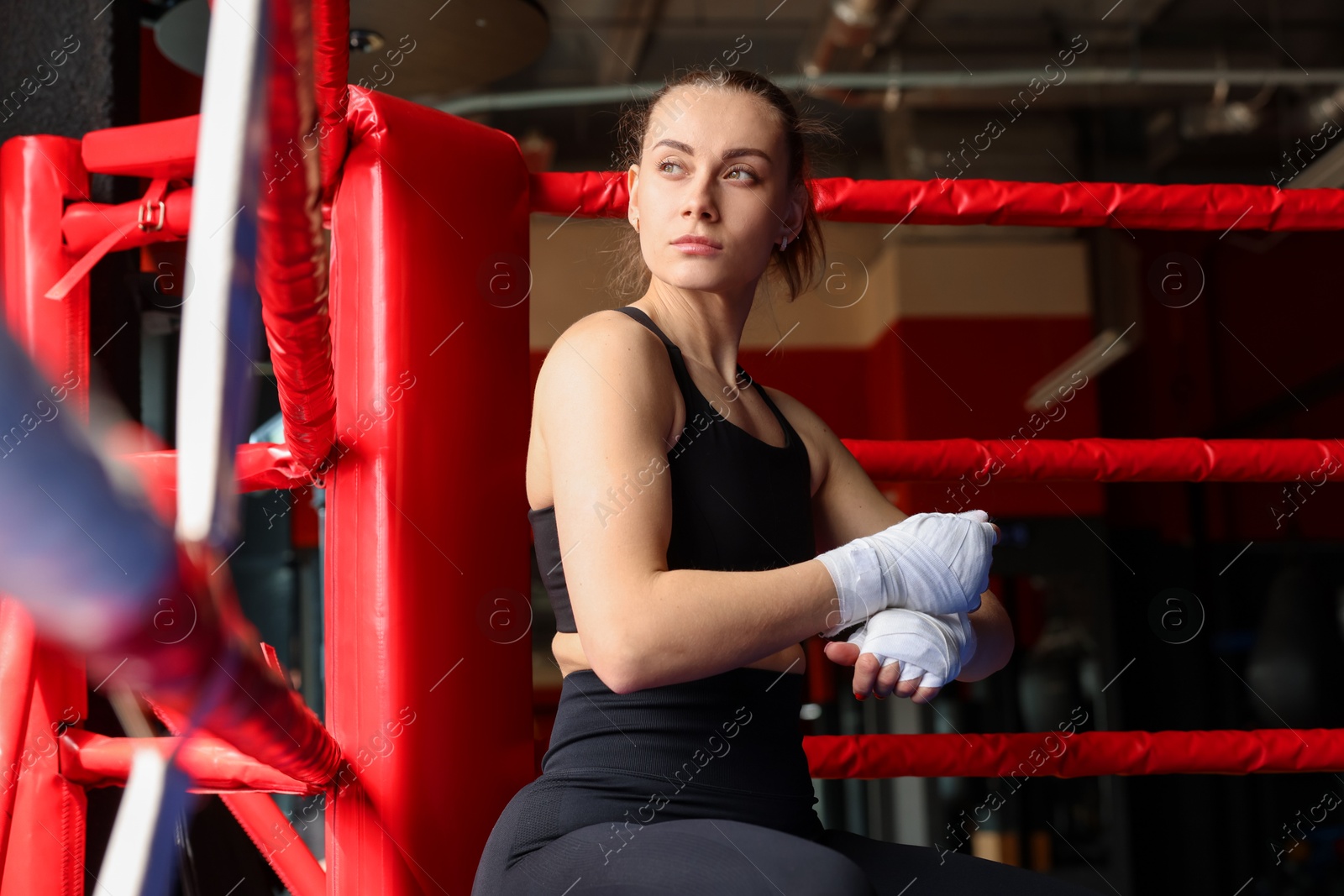 Woman wrapping her hands on boxing ring Photo of Woman wrapping her hands on boxing ring
