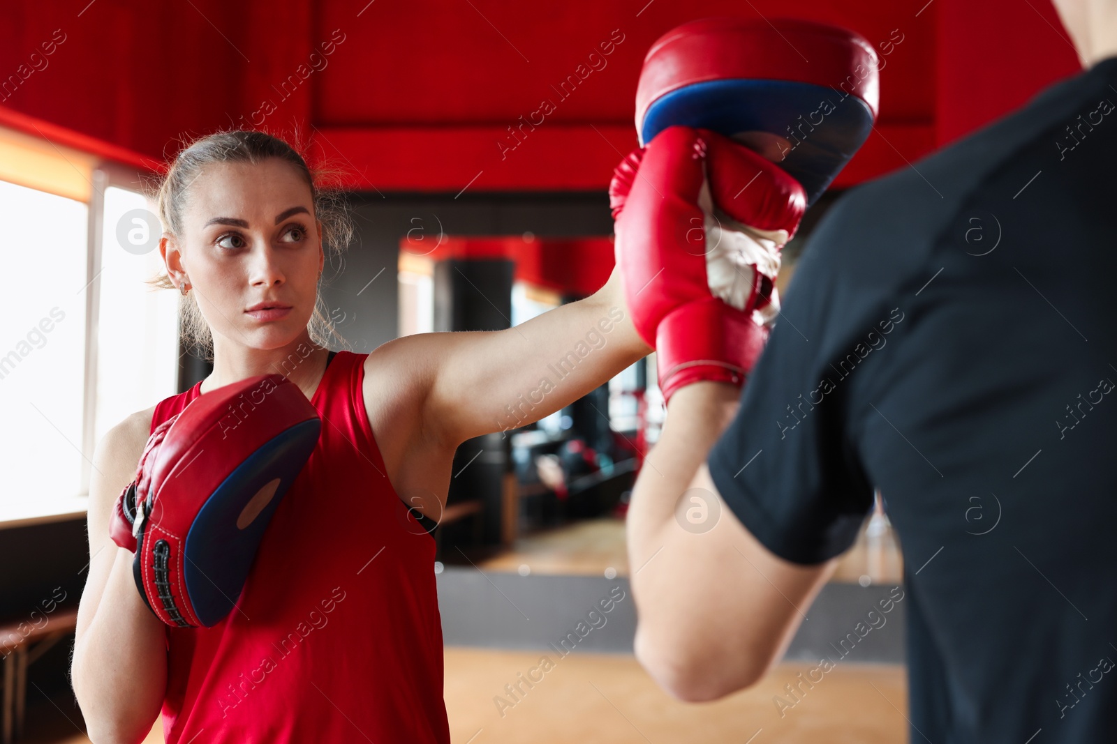 Boxing coach training man in sport center Photo of Boxing coach training man in sport center