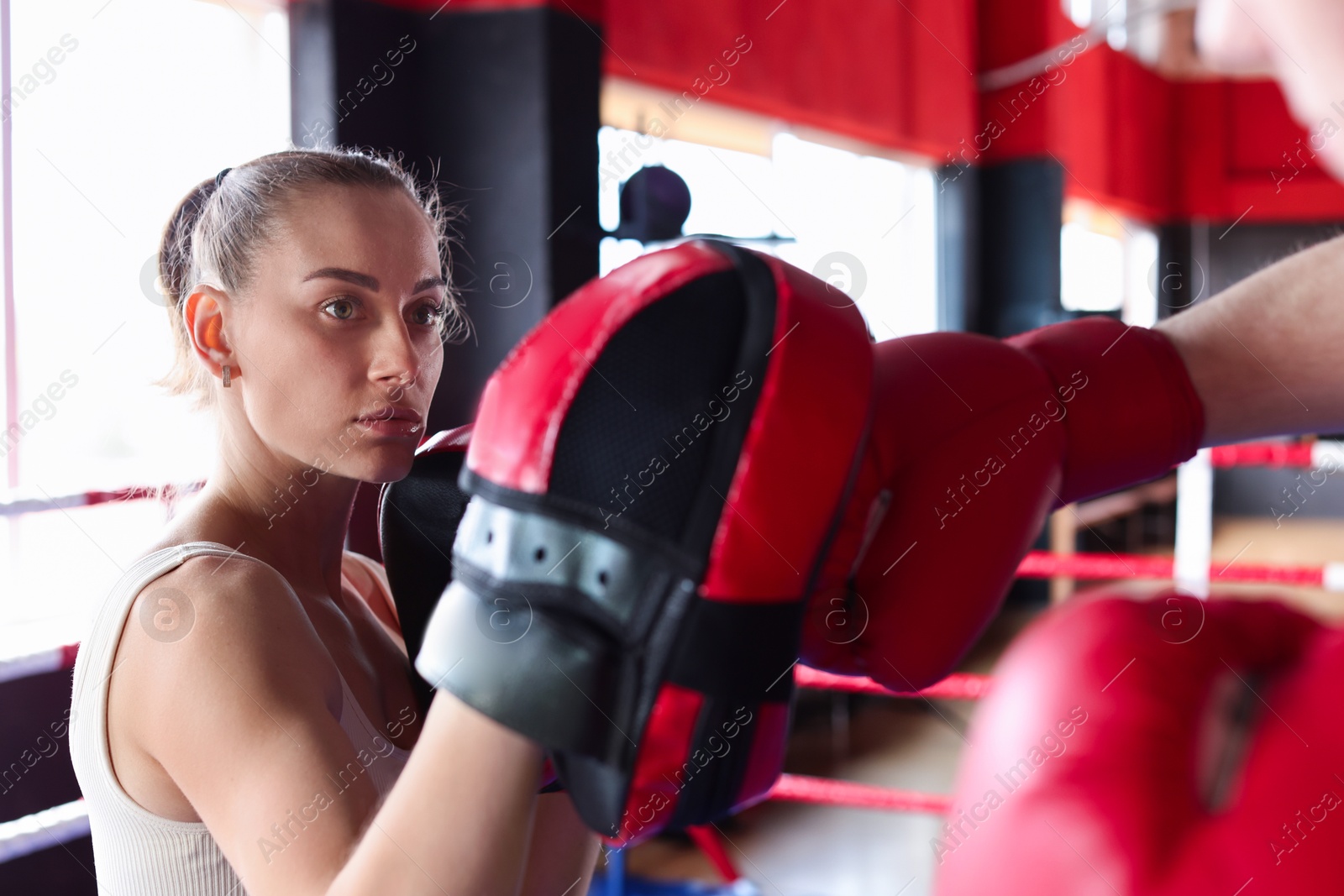 Photo of Boxing coach training man in sport center