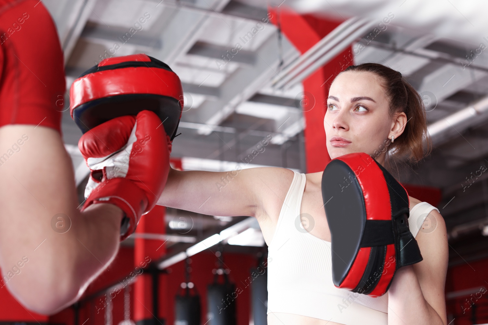 Boxing coach training man in sport center Photo of Boxing coach training man in sport center
