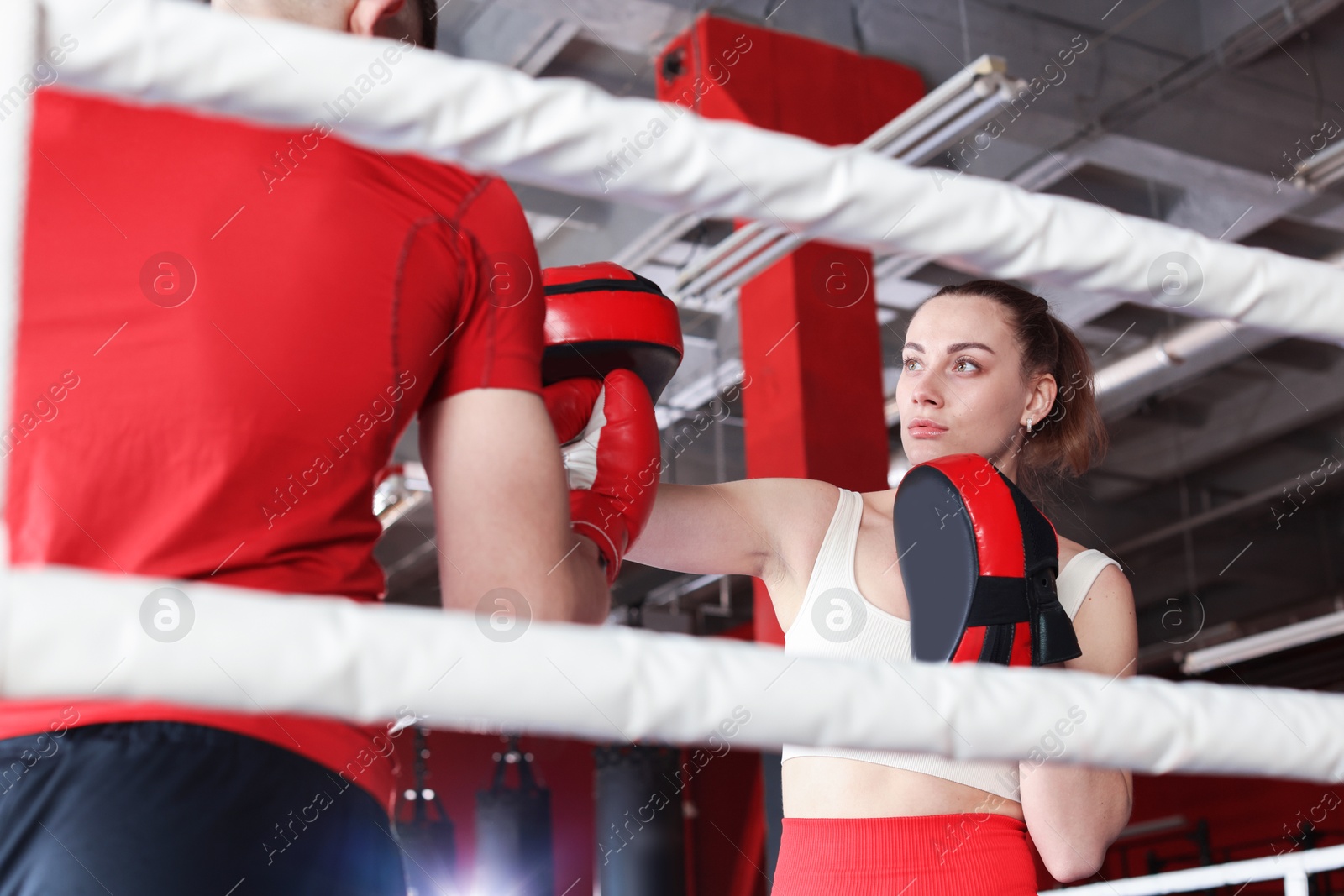 Boxing coach training man in sport center Photo of Boxing coach training man in sport center