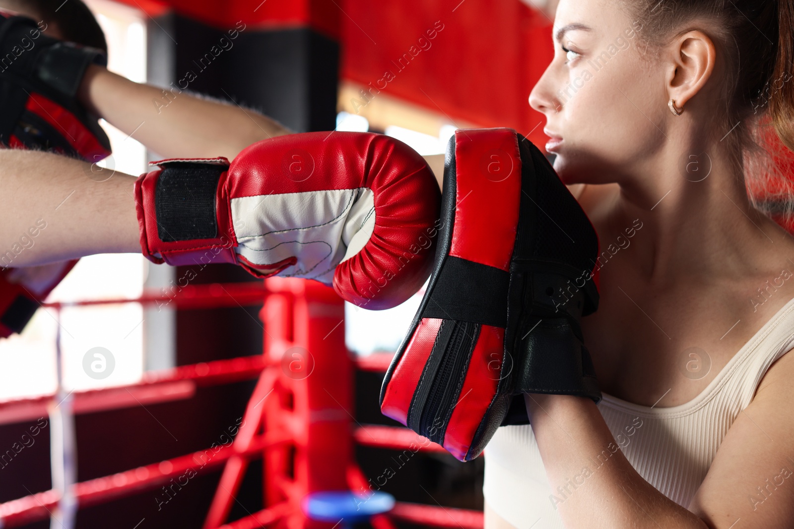 Boxing coach training man in sport center, closeup Photo of Boxing coach training man in sport center, closeup