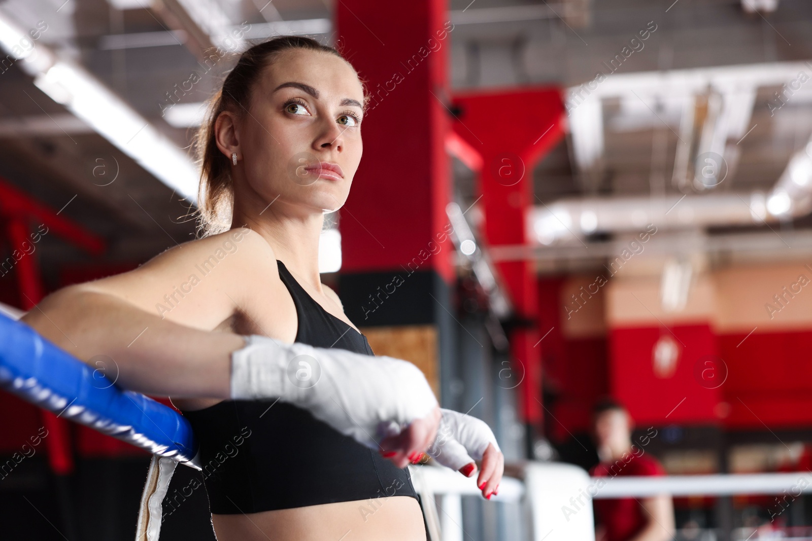 Woman with protective gloves on boxing ring. Space for text Photo of Woman with protective gloves on boxing ring. Space for text