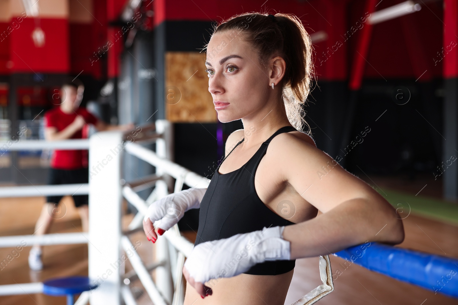 Woman with protective gloves on boxing ring Photo of Woman with protective gloves on boxing ring