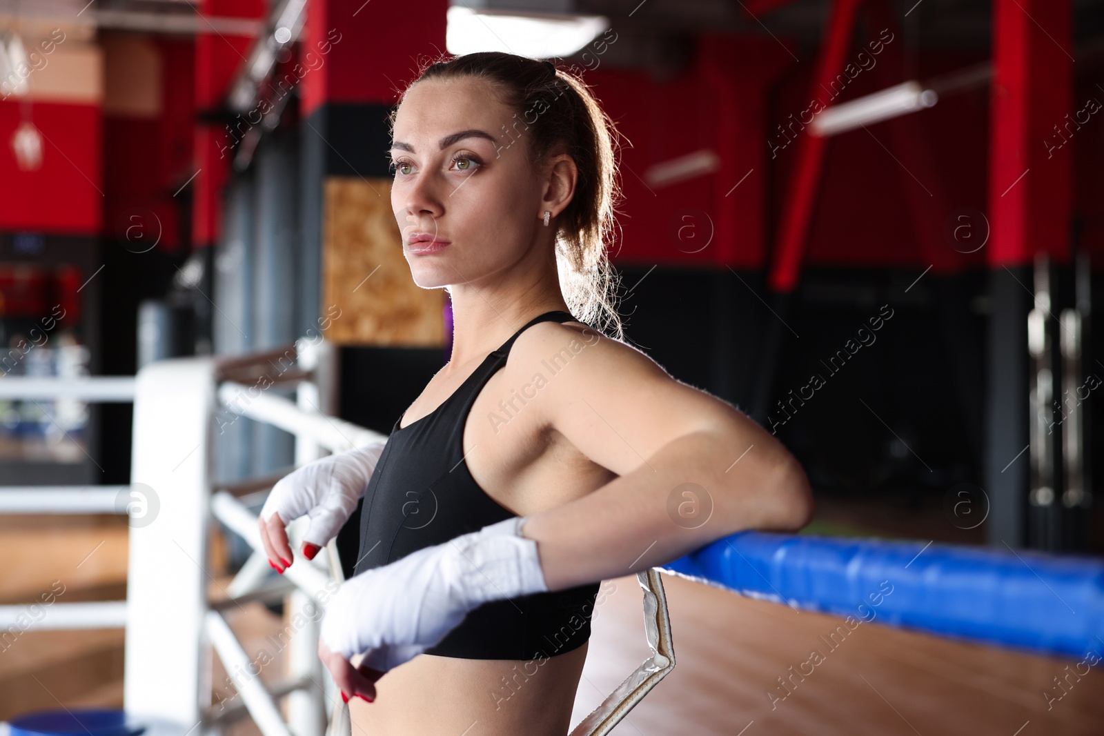 Woman with protective gloves on boxing ring Photo of Woman with protective gloves on boxing ring