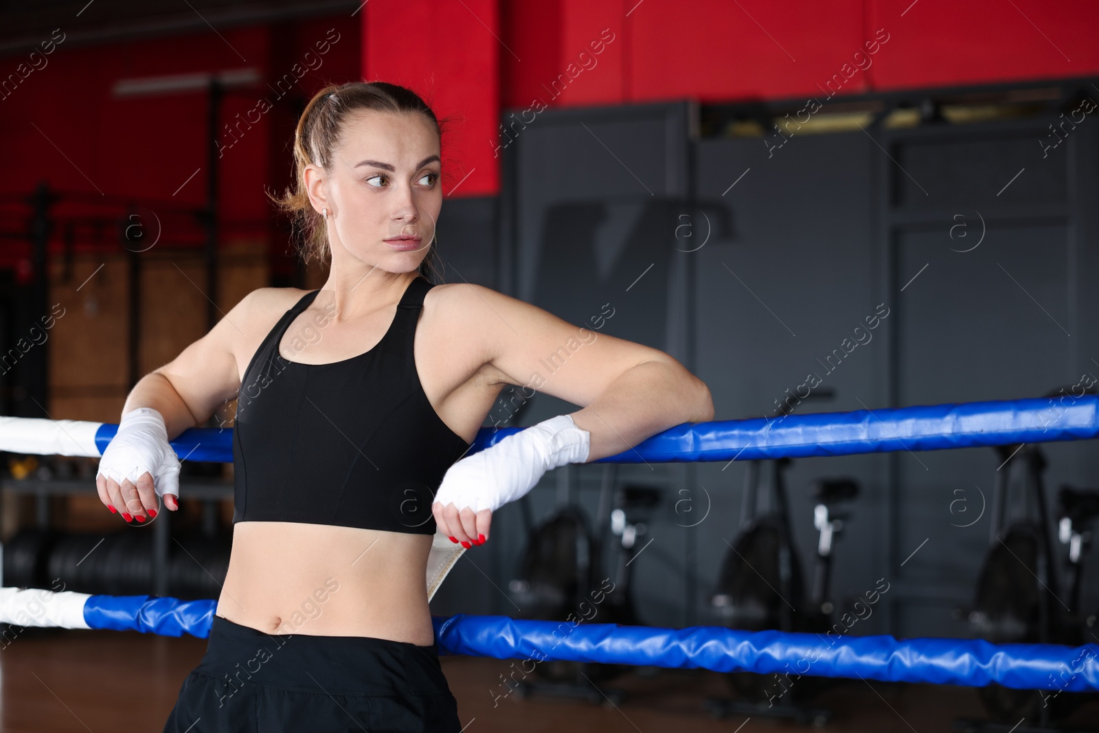 Photo of Woman with protective gloves on boxing ring. Space for text