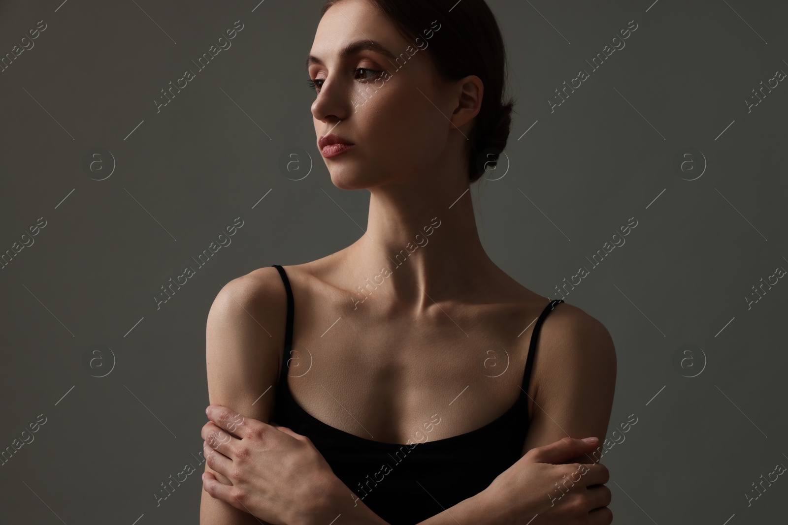 Woman with perfect skin on grey background Photo of Woman with perfect skin on grey background