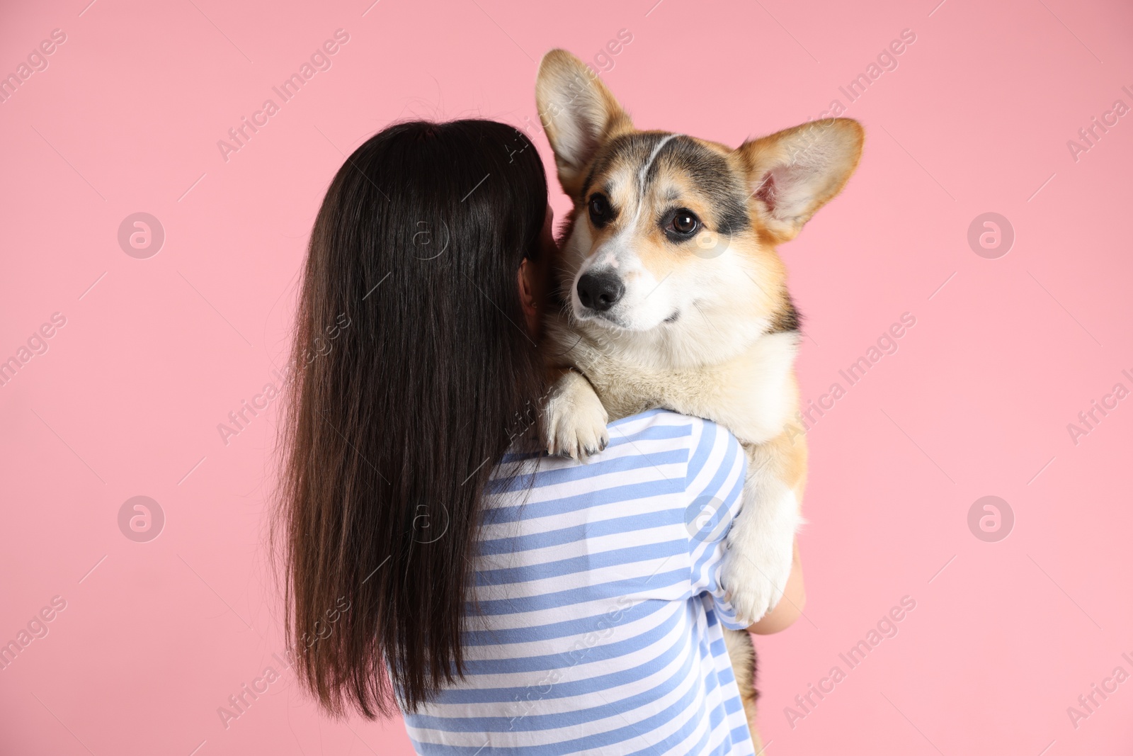 Animal training. Woman with her cute dog on pink background, back view Photo of Animal training. Woman with her cute dog on pink background, back view