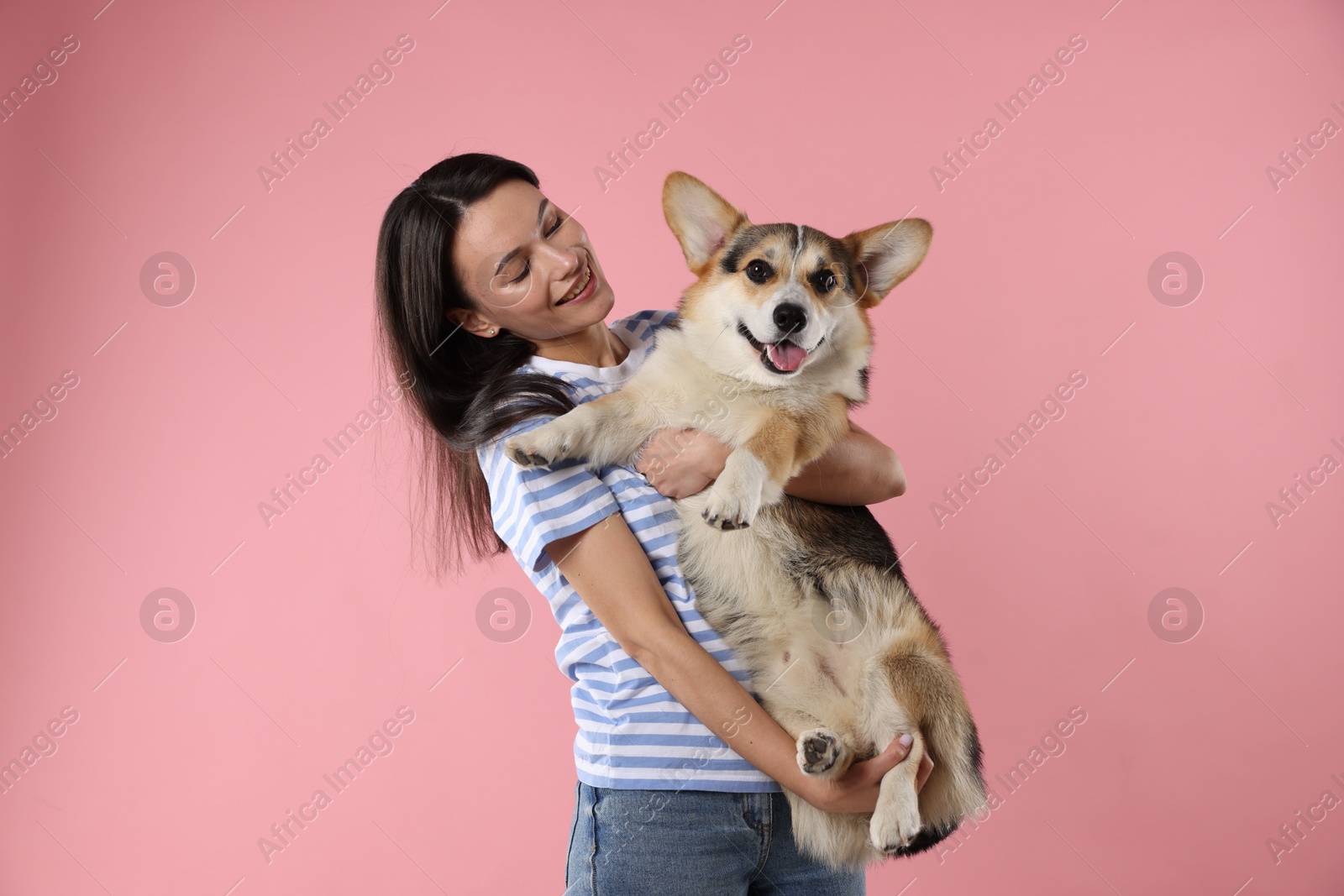 Animal training. Woman with her cute dog on pink background Photo of Animal training. Woman with her cute dog on pink background