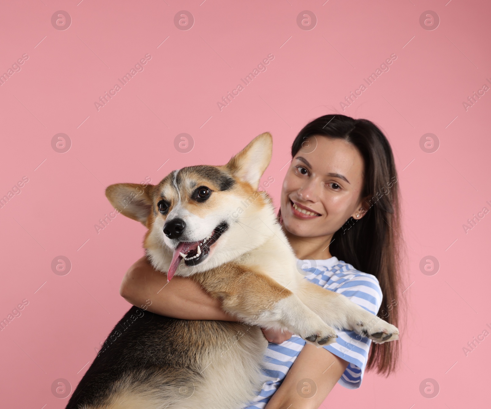 Animal training. Woman with her cute dog on pink background Photo of Animal training. Woman with her cute dog on pink background