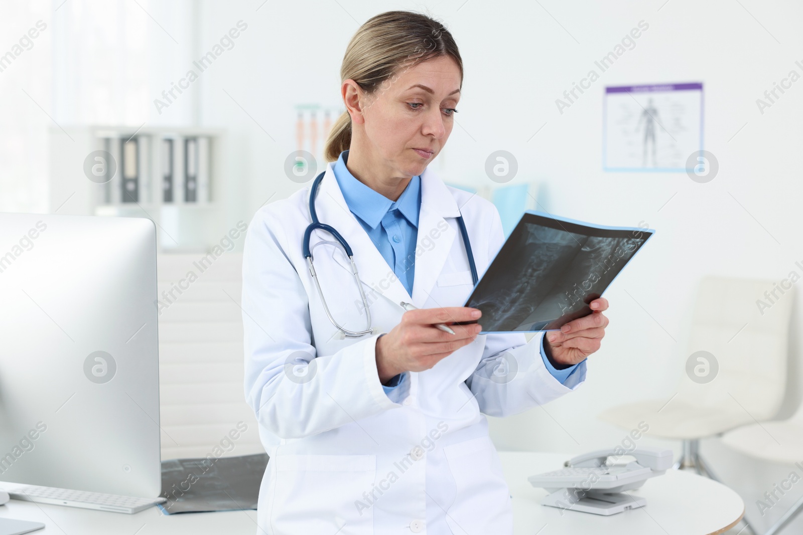 Doctor examining MRI scan at desk in hospital Photo of Doctor examining MRI scan at desk in hospital