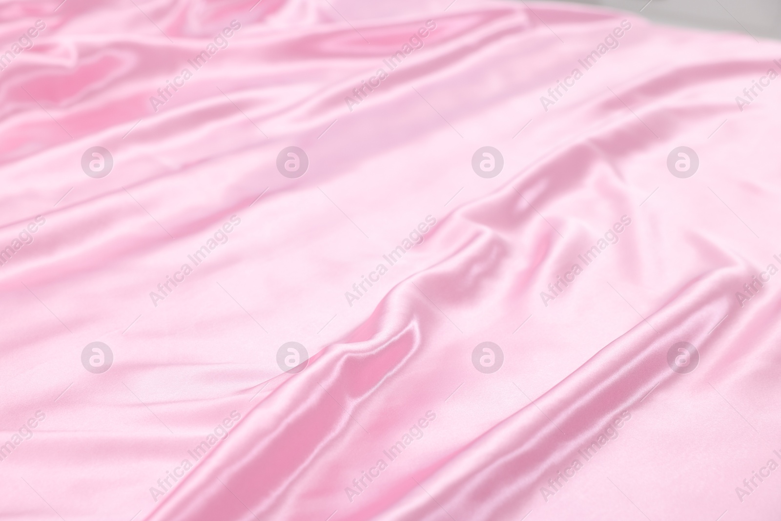 Luxury pink silk linens on bed, closeup Photo of Luxury pink silk linens on bed, closeup