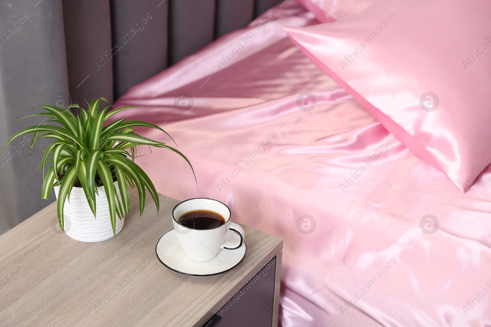 Luxury silk linens on bed and nightstand at home Photo of Luxury silk linens on bed and nightstand at home