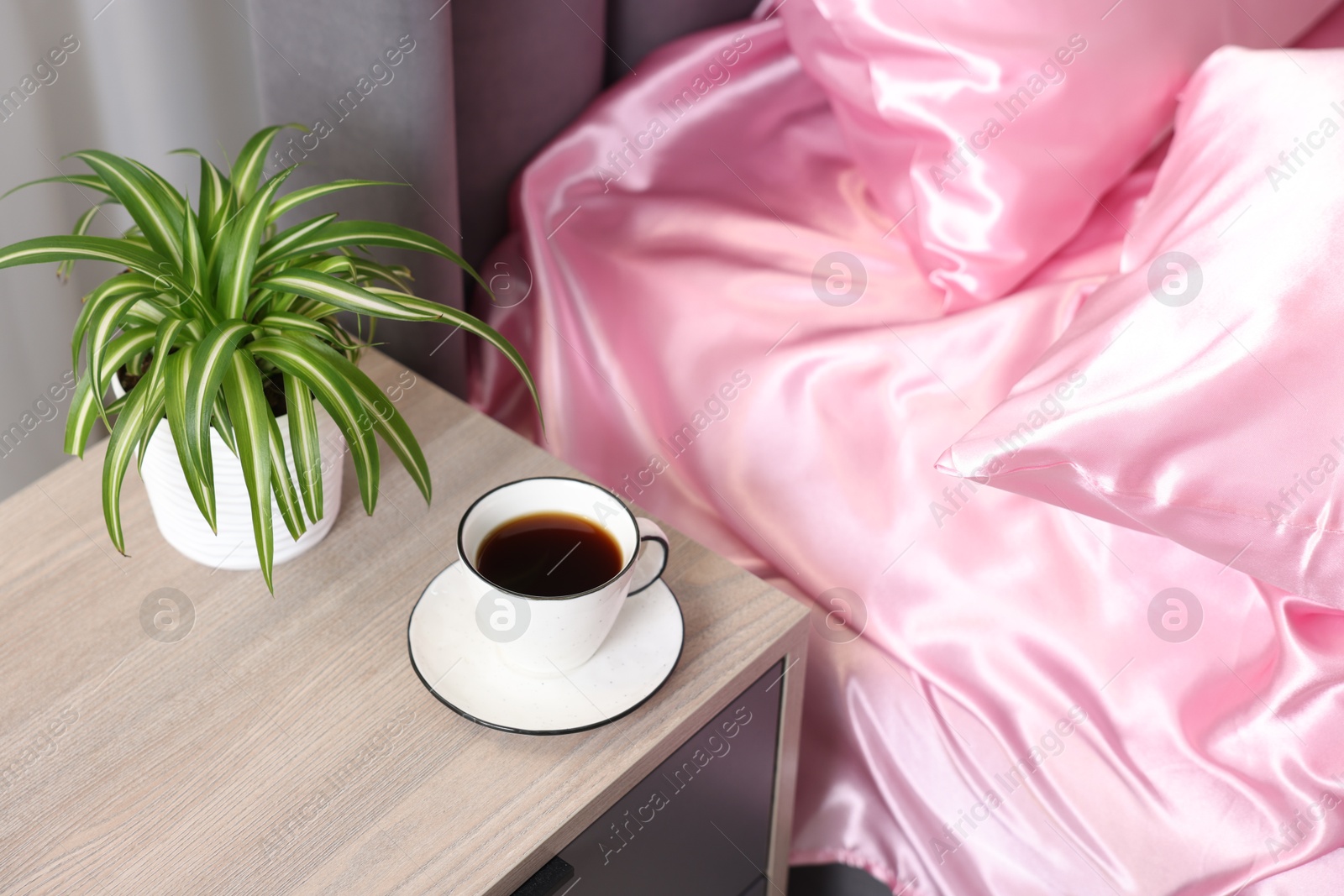 Luxury silk linens on bed and nightstand at home Photo of Luxury silk linens on bed and nightstand at home