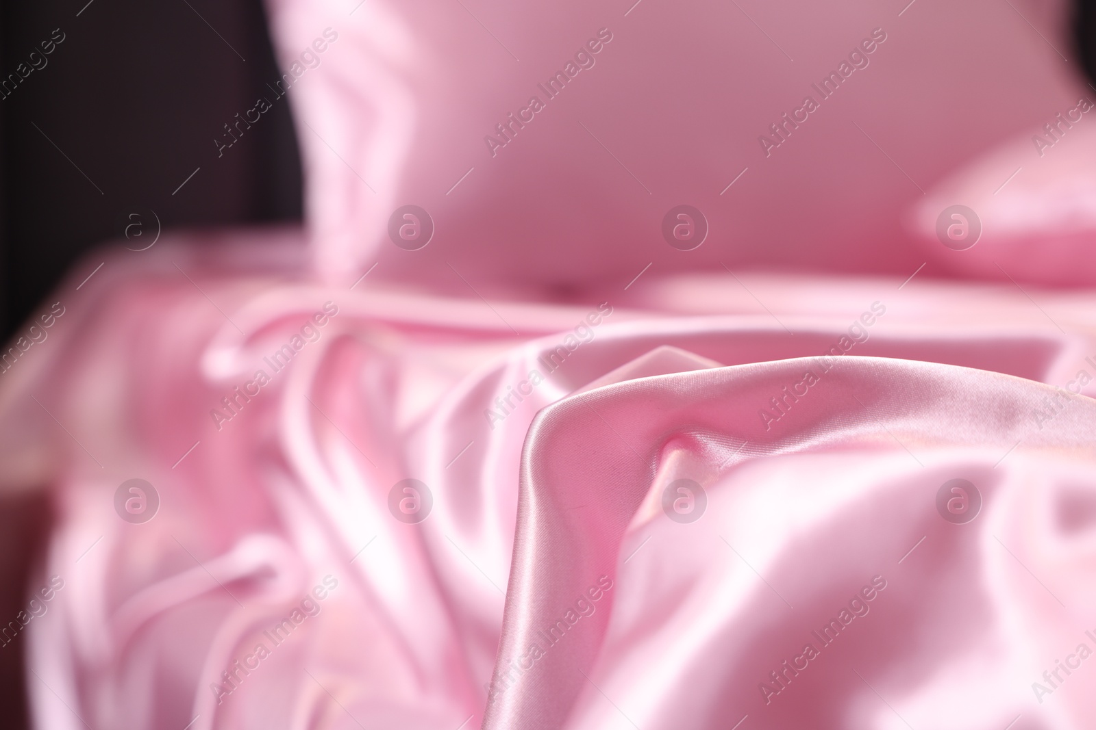 Luxury pink silk linens on bed, closeup Photo of Luxury pink silk linens on bed, closeup