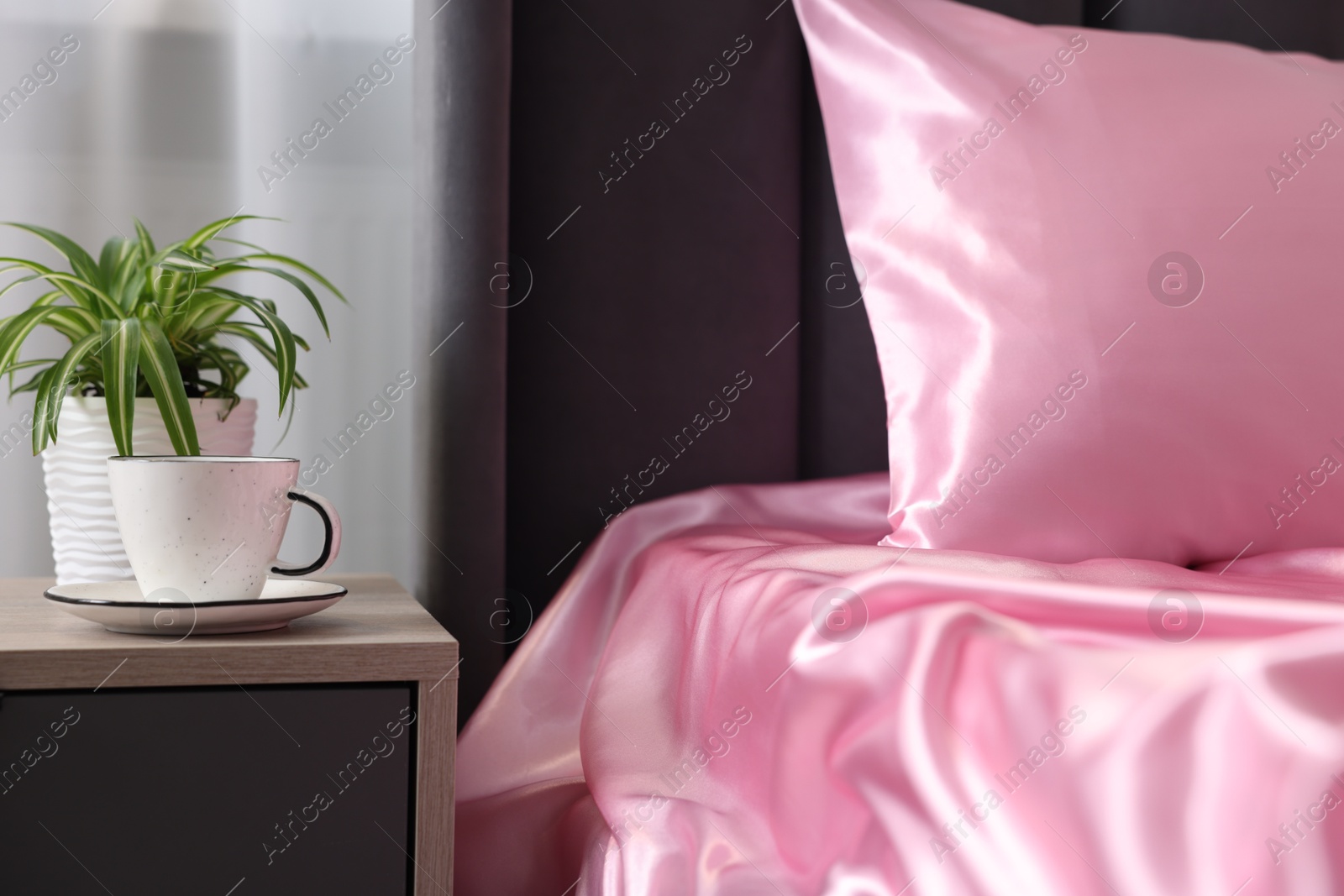 Luxury silk linens on bed and nightstand at home Photo of Luxury silk linens on bed and nightstand at home