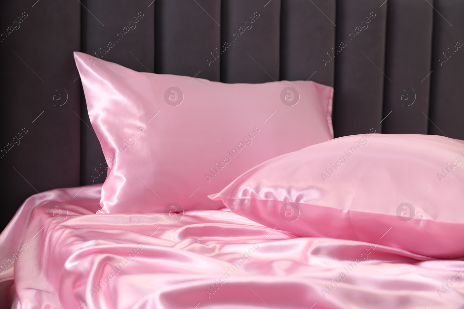 Luxury pink silk linens on bed, closeup Photo of Luxury pink silk linens on bed, closeup