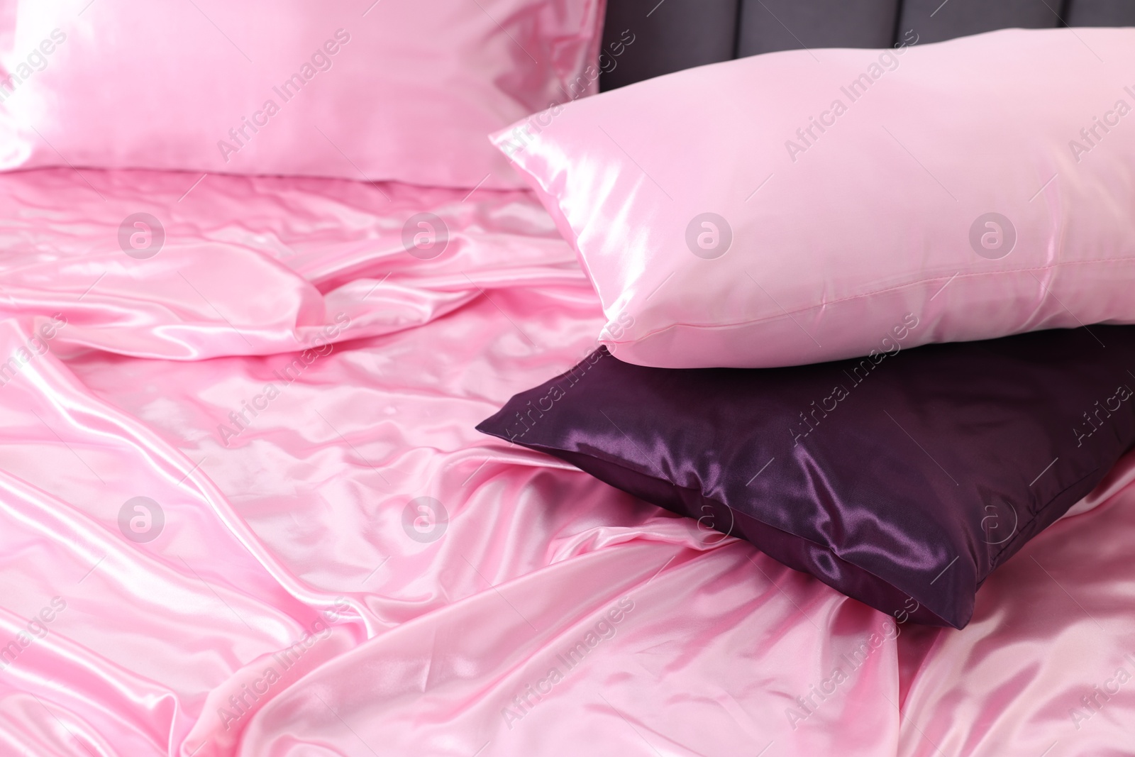 Luxury pink silk linens and pillows on bed Photo of Luxury pink silk linens and pillows on bed