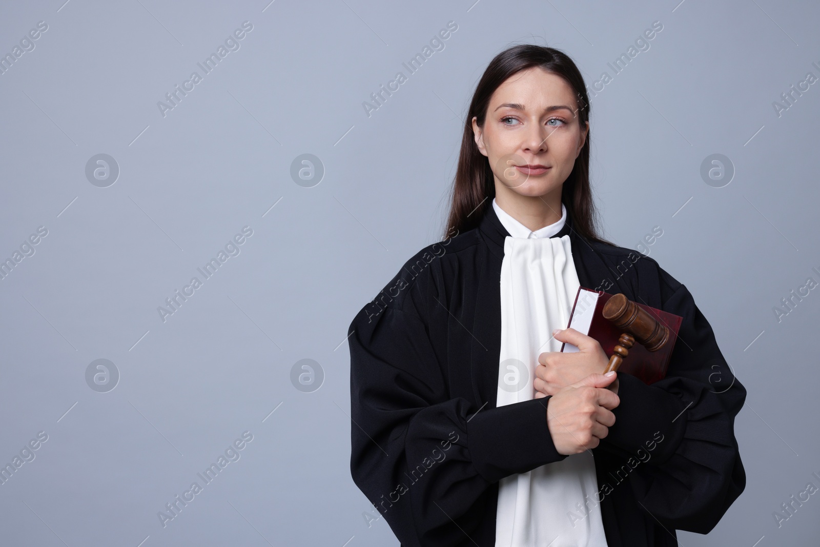 Judge with mallet and book on gray background, space for text Photo of Judge with mallet and book on gray background, space for text