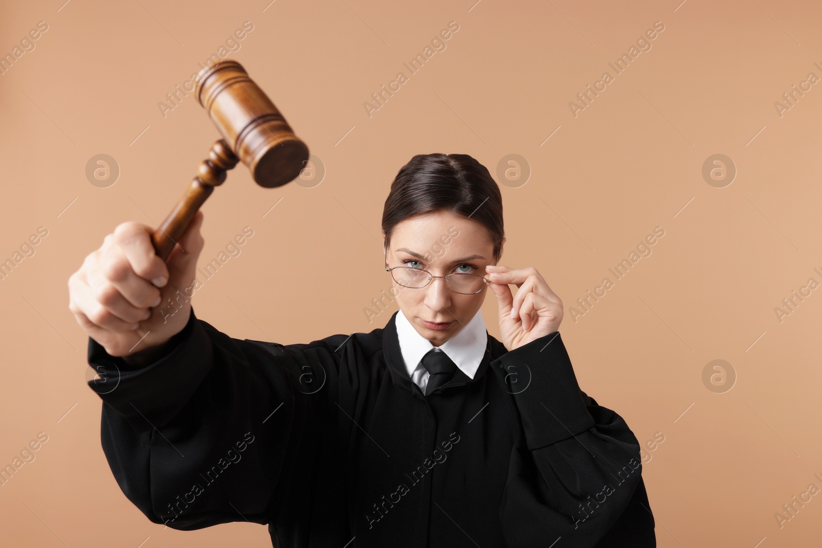 Judge with mallet on light brown background Photo of Judge with mallet on light brown background
