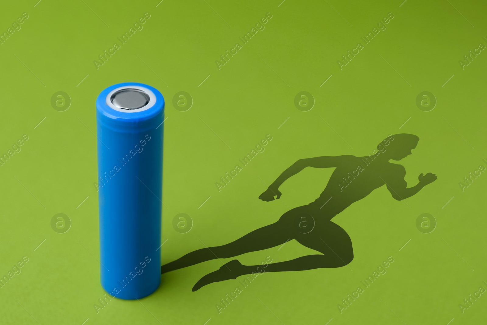 Alkaline battery with shadow in shape of running man on green background Illustration of Alkaline battery with shadow in shape of running man on green background