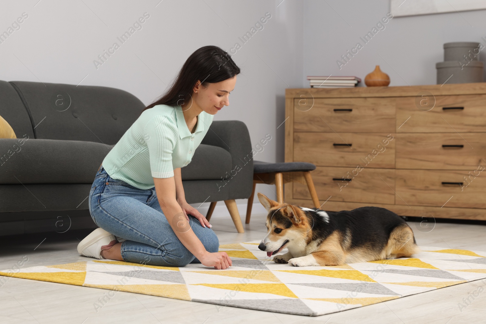 Woman training her dog on floor at home Photo of Woman training her dog on floor at home