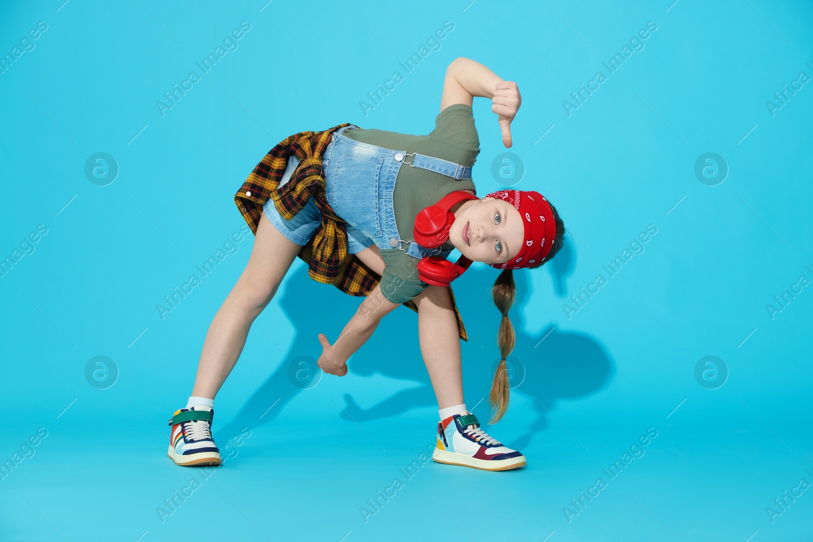 Photo of Girl with headphones dancing on light blue background