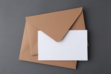 Photo of Blank greeting card and envelopes on grey background, top view