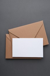 Photo of Blank greeting card and envelopes on grey background, top view