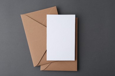 Photo of Blank greeting card and envelopes on grey background, top view