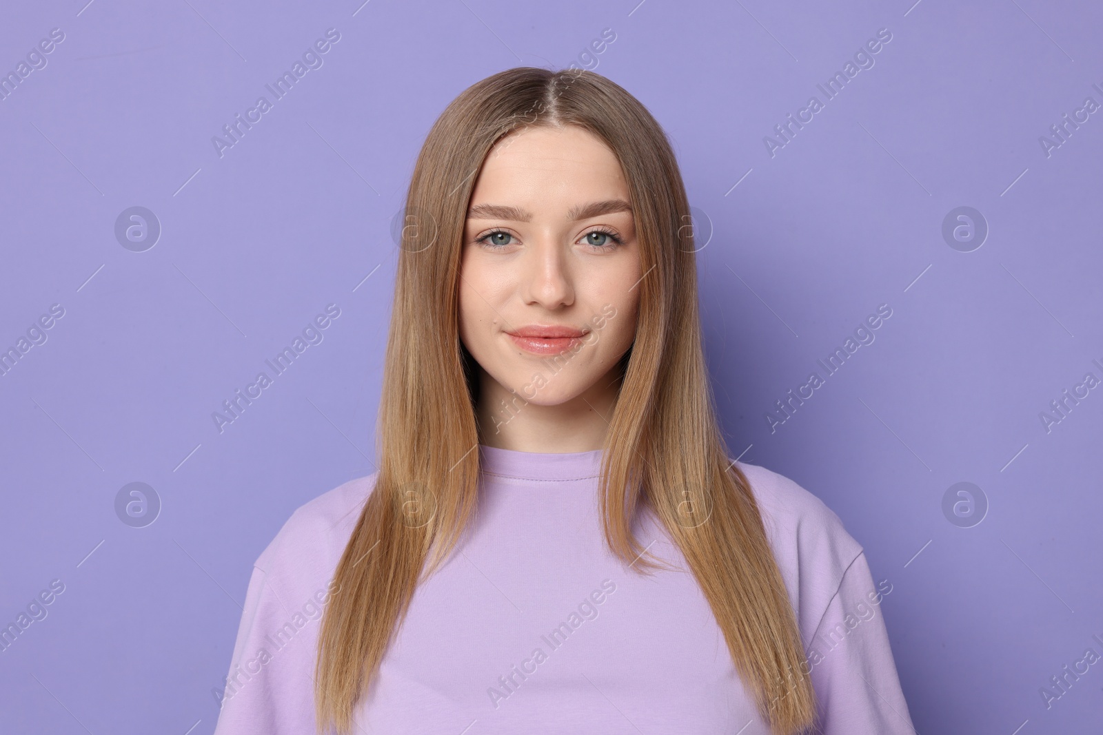 Portrait of beautiful teenage girl on violet background Photo of Portrait of beautiful teenage girl on violet background