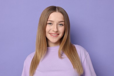 Photo of Portrait of smiling teenage girl on violet background