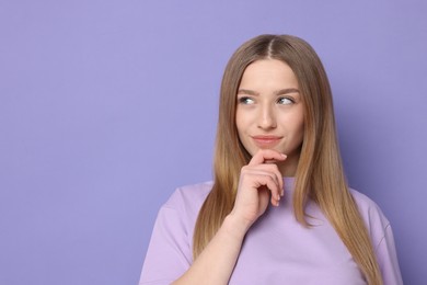 Photo of Portrait of thoughtful teenage girl on violet background. Space for text