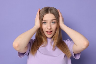 Photo of Portrait of emotional teenage girl on violet background