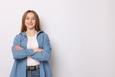 Photo of Portrait of smiling teenage girl on white background. Space for text