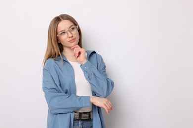 Photo of Thoughtful teenage girl on white background. Space for text