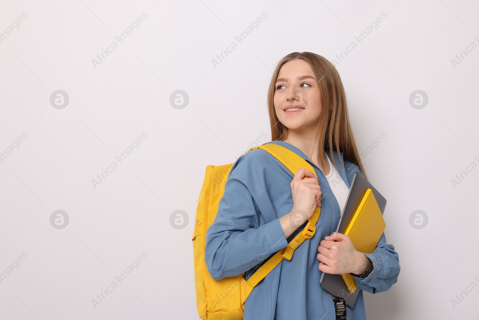 Smiling teenage girl with books and backpack on white background. Space for text Photo of Smiling teenage girl with books and backpack on white background. Space for text